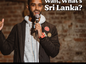 A comedian performing in front of brick wall.